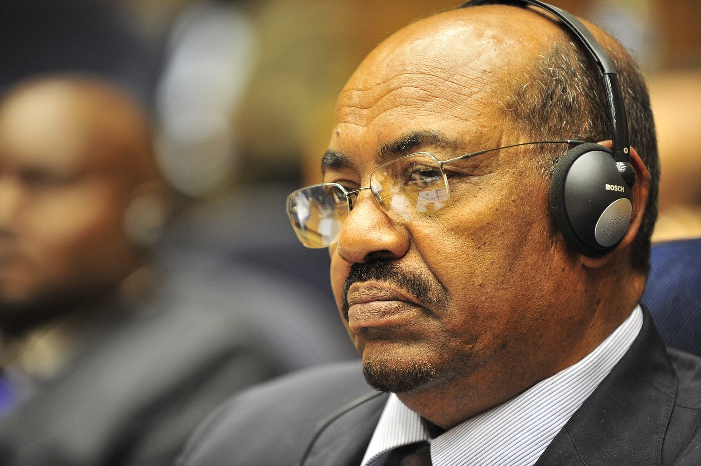 Close-up photograph of Omar al-Bashir, then president of Sudan, wearing glasses and interpretation headphones while listening to a speech in Addis Ababa, January 31, 2009.