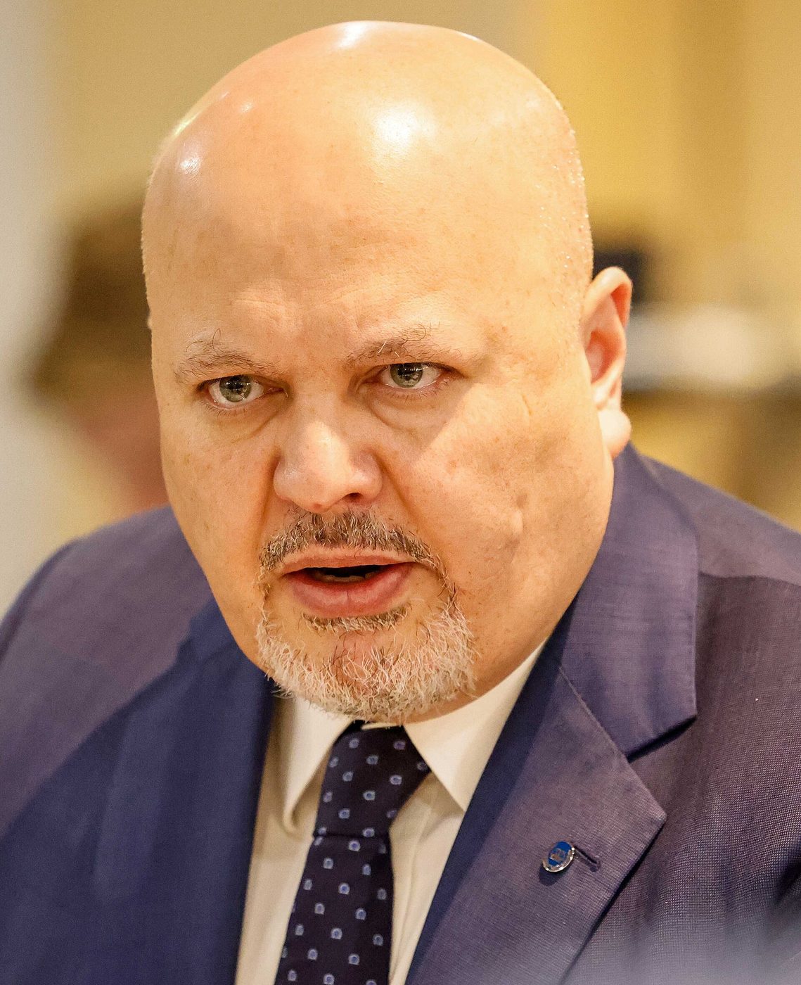 Close-up photograph of Karim Khan, then ICC prosecutor, speaking, in a blue suit and dark tie, during a meeting with EU foreign ministers in Brussels, April 2022.