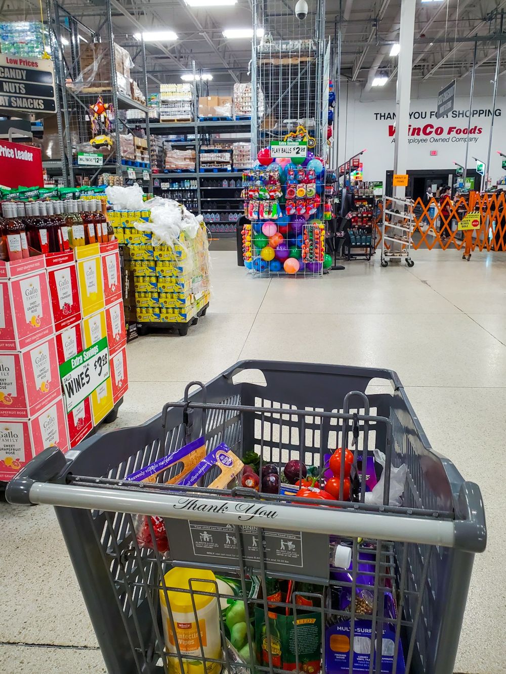 Shopping cart with groceries in a supermarket aisle